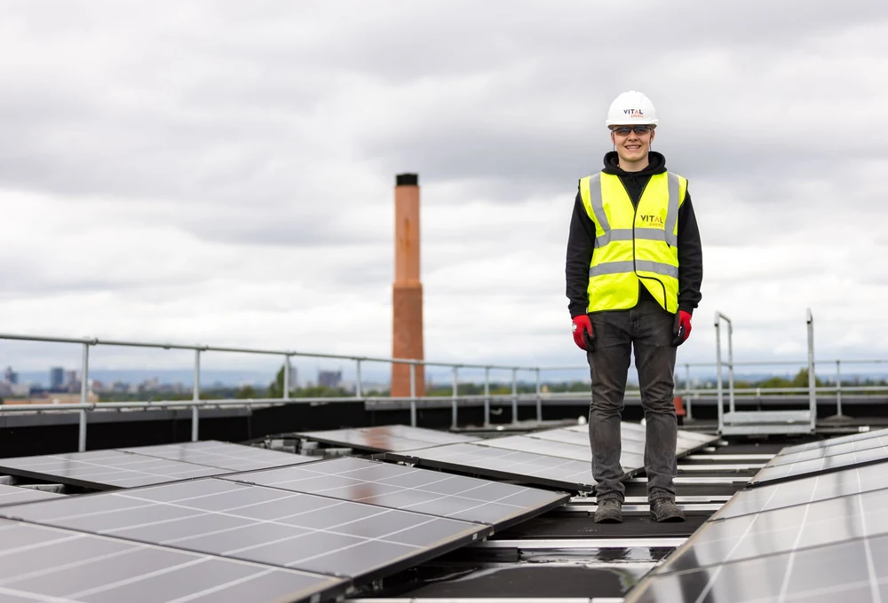 Tenaga teknis berhelm berdiri di antara panel surya - foto stok ilustratif, bukan proyek atau dukungan Greenova Energi